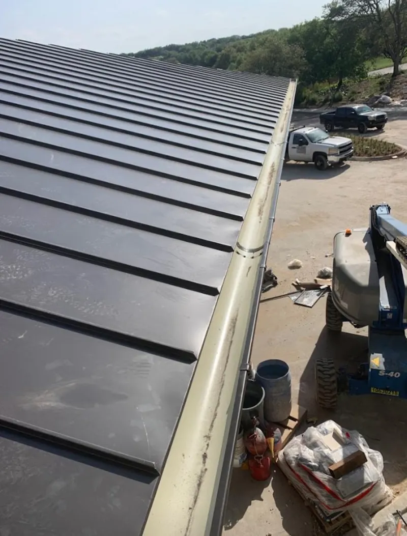 Standing seam panel and gutter detail on a metal roofing jobsite in Fridley